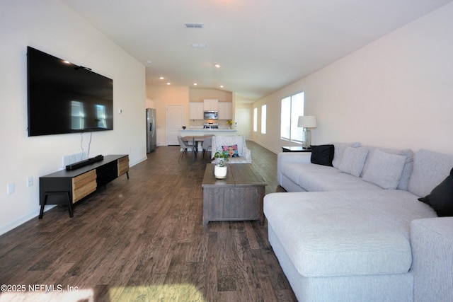 living room featuring dark hardwood / wood-style flooring and vaulted ceiling