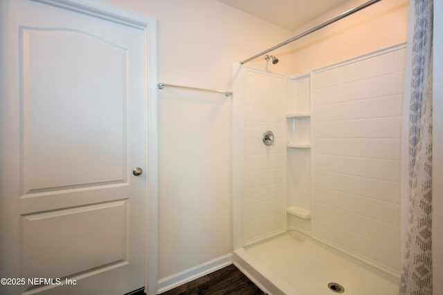 bathroom with wood-type flooring and walk in shower