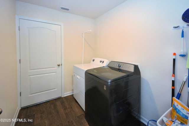 laundry room with washing machine and clothes dryer and dark hardwood / wood-style flooring