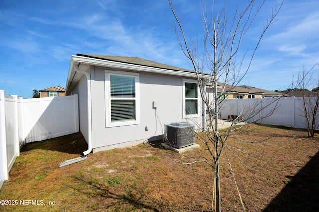 back of house featuring cooling unit and a lawn