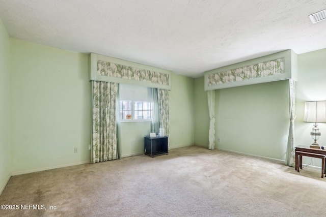 carpeted empty room with a textured ceiling