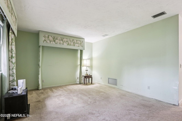 carpeted empty room with a textured ceiling