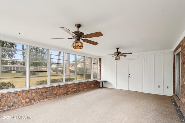 unfurnished sunroom with ceiling fan