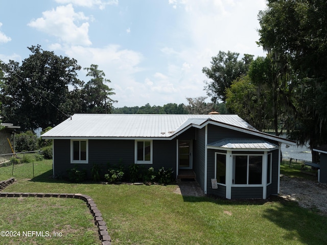 view of front of home with a front yard and a sunroom