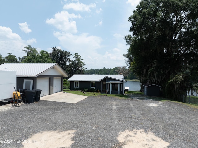 ranch-style house with a garage, a sunroom, and a shed