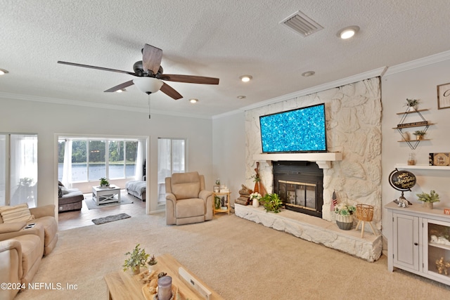 carpeted living room with ceiling fan, a fireplace, crown molding, and a textured ceiling