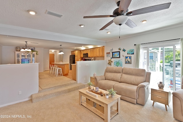 living room with a textured ceiling, ornamental molding, and light colored carpet