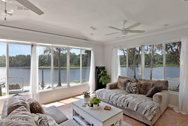 sunroom featuring ceiling fan, a wealth of natural light, and a water view