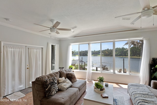 tiled living room featuring a textured ceiling, ceiling fan, and a water view