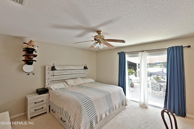 carpeted bedroom featuring ceiling fan, access to exterior, and a textured ceiling