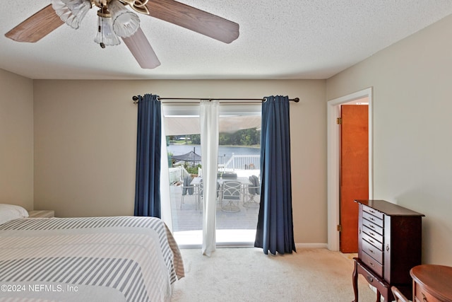 carpeted bedroom featuring ceiling fan, access to exterior, and a textured ceiling