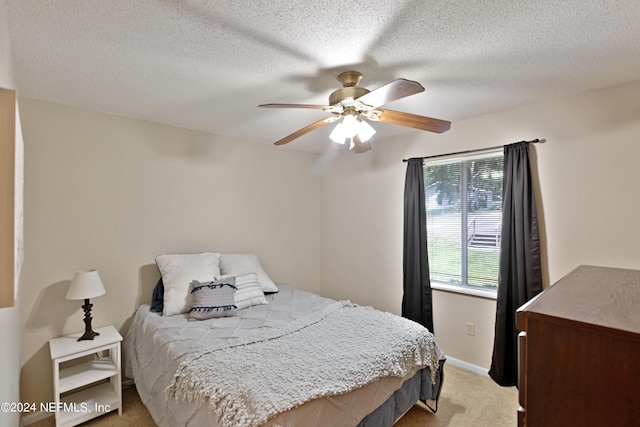 carpeted bedroom with ceiling fan, multiple windows, and a textured ceiling