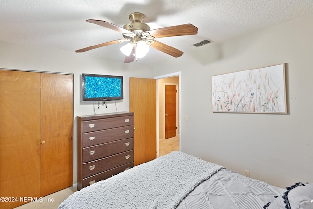 bedroom featuring a textured ceiling, ceiling fan, and a closet