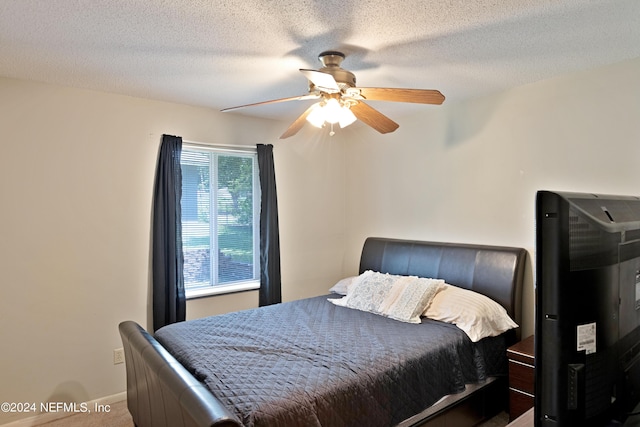 carpeted bedroom with a textured ceiling and ceiling fan