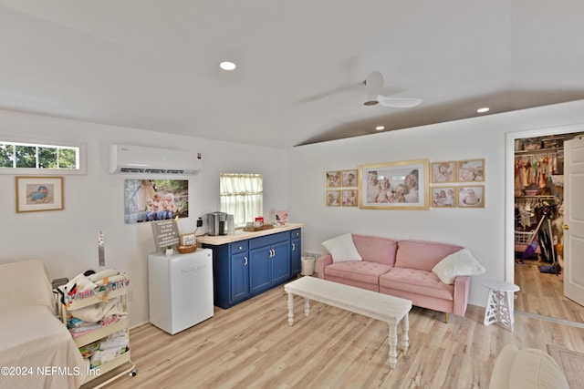 living room featuring plenty of natural light, a wall mounted AC, and light wood-type flooring