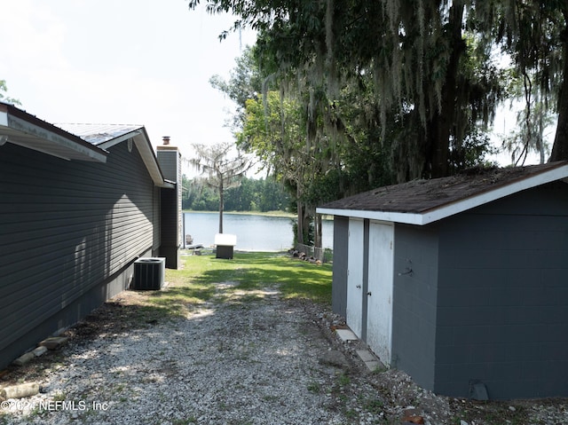 view of yard featuring central AC unit and a water view