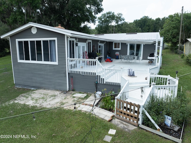 view of front facade with a wooden deck and a front yard