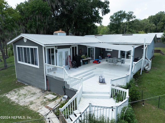 rear view of house featuring a deck and a yard