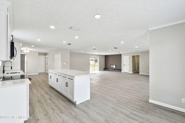 kitchen featuring white cabinetry, baseboards, stainless steel appliances, and a sink