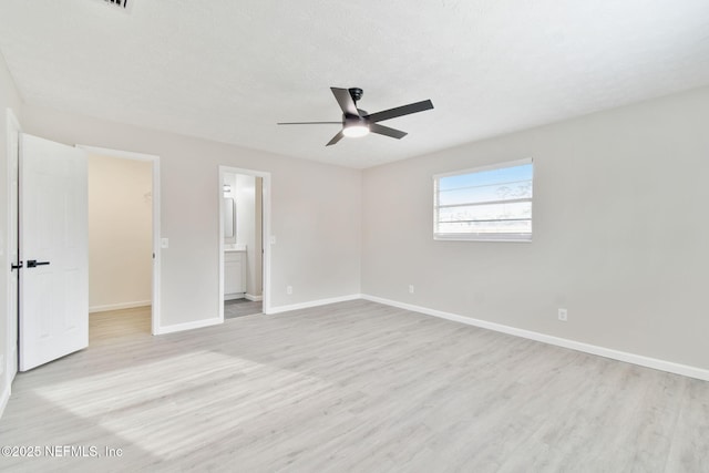 unfurnished bedroom featuring light wood finished floors, a textured ceiling, and baseboards