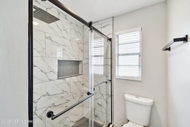 bathroom with toilet and a marble finish shower