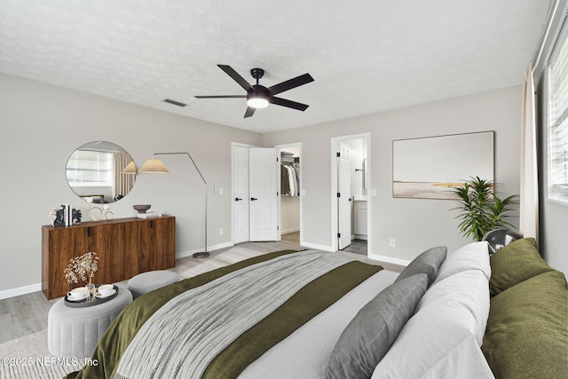 bedroom with visible vents, multiple windows, baseboards, and wood finished floors