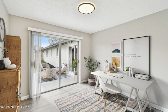 office space featuring light wood-type flooring and baseboards