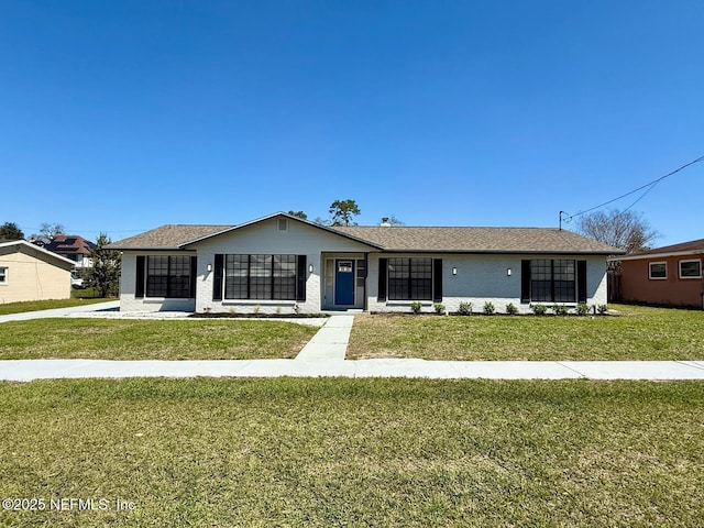 view of front of property with a front lawn, brick siding, and roof with shingles