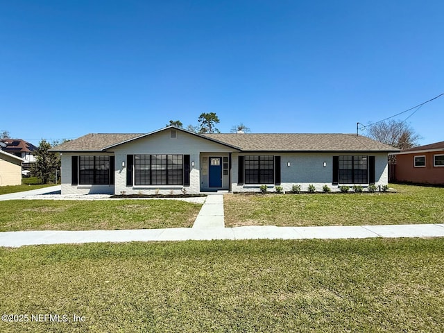 view of front of house featuring brick siding, an attached garage, a shingled roof, and a front yard