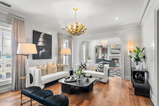 living room featuring a chandelier, ornamental molding, and hardwood / wood-style flooring