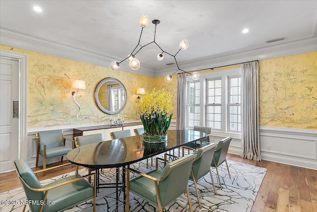 dining room with wood-type flooring and crown molding