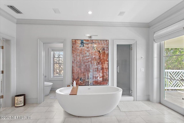 bathroom featuring crown molding, toilet, a bathing tub, and tile patterned flooring