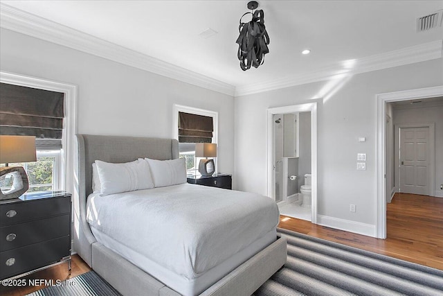 bedroom with wood-type flooring, ensuite bathroom, and crown molding