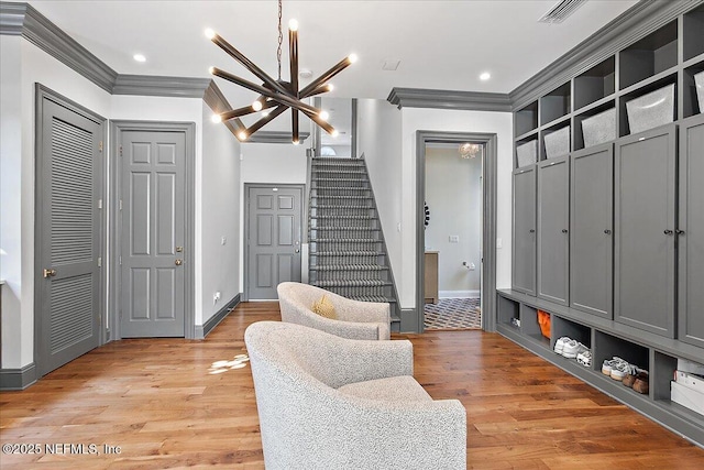 mudroom featuring light wood-type flooring, an inviting chandelier, and ornamental molding