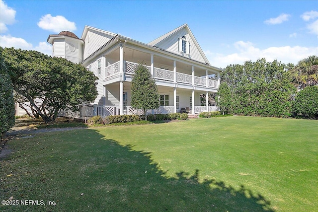 view of front of home featuring a front lawn, a balcony, and covered porch