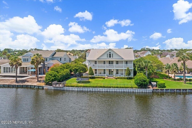 rear view of property with a water view and a yard