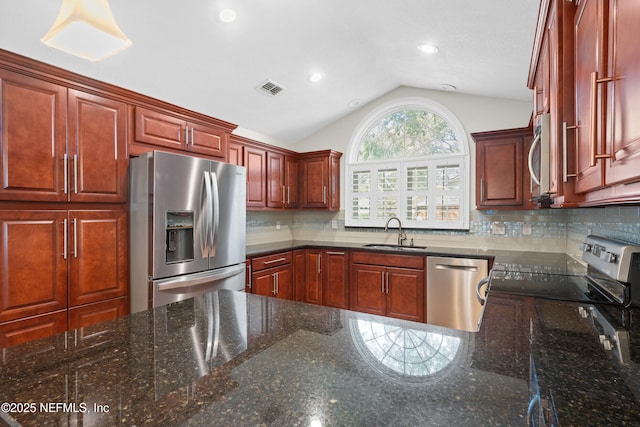 kitchen featuring appliances with stainless steel finishes, sink, and dark stone countertops