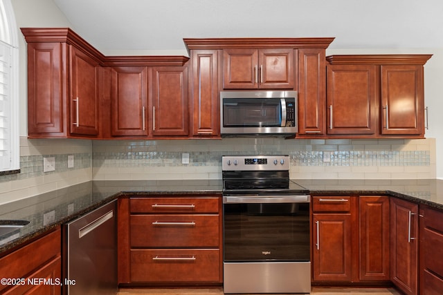 kitchen featuring appliances with stainless steel finishes, decorative backsplash, and dark stone counters