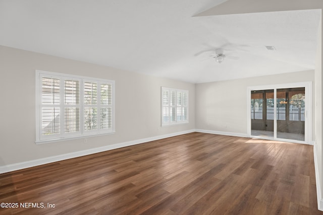 unfurnished room with a healthy amount of sunlight, dark wood-type flooring, and ceiling fan