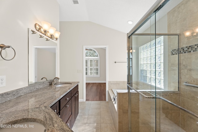 bathroom with a healthy amount of sunlight, separate shower and tub, vaulted ceiling, and vanity