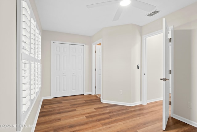 unfurnished bedroom with ceiling fan, hardwood / wood-style floors, and a closet