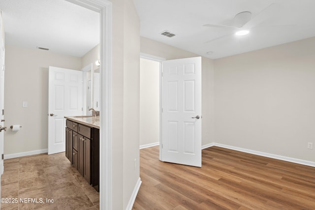 bathroom featuring wood-type flooring, vanity, and ceiling fan