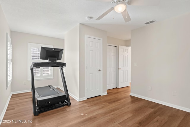 exercise room with hardwood / wood-style flooring and ceiling fan