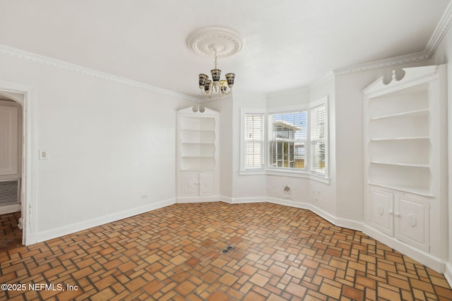 empty room featuring crown molding and a chandelier