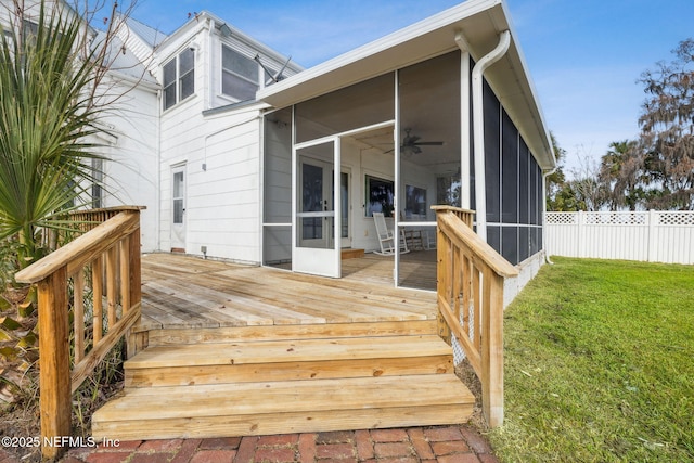 wooden terrace featuring ceiling fan, a yard, and a sunroom