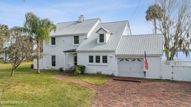 back of house featuring a garage and a lawn