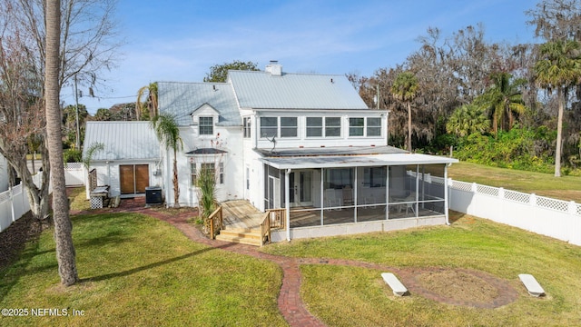 back of house featuring a sunroom, cooling unit, and a lawn