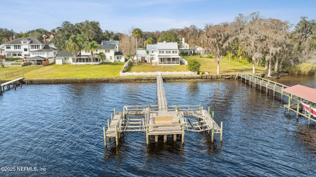 view of dock with a water view and a lawn