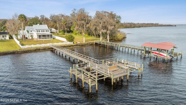 view of dock with a yard and a water view