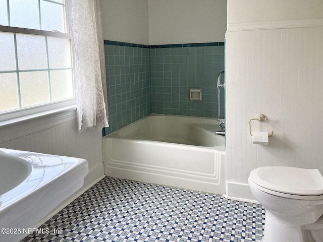 bathroom featuring tile patterned flooring, wooden walls, and toilet